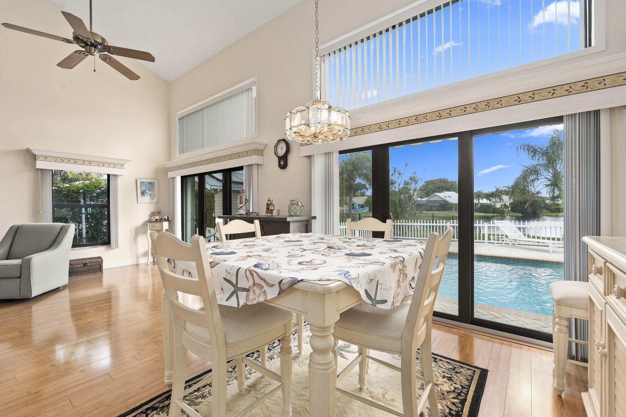 8964 Southeast Sunfish Place Hobe Sound, FL 33455 - Photo 16 of 51 a view of a dining room with furniture large windows and wooden floor