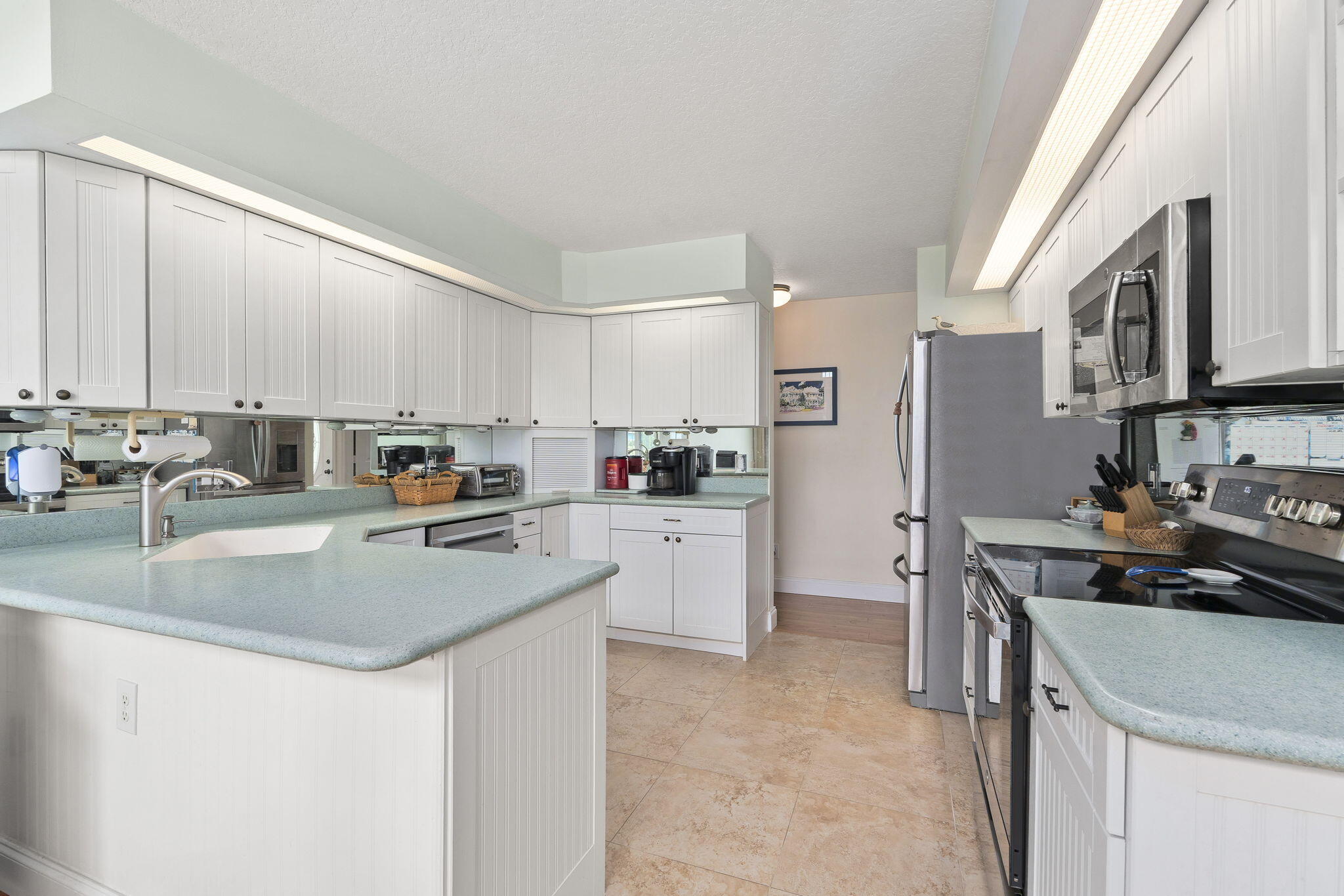 8964 Southeast Sunfish Place Hobe Sound, FL 33455 - Photo 19 of 51 a kitchen with stainless steel appliances granite countertop a sink stove and refrigerator