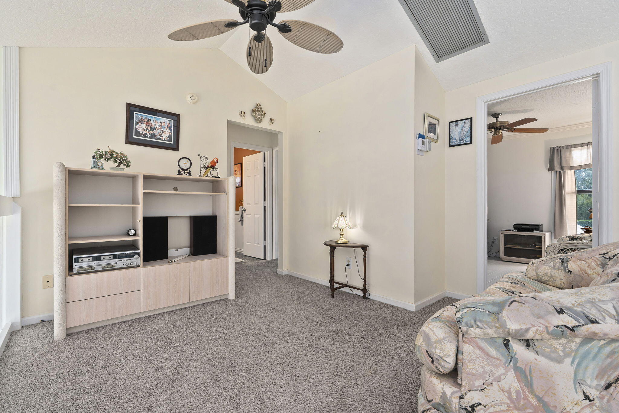 8964 Southeast Sunfish Place Hobe Sound, FL 33455 - Photo 24 of 51 a bedroom with a bed and a chandelier