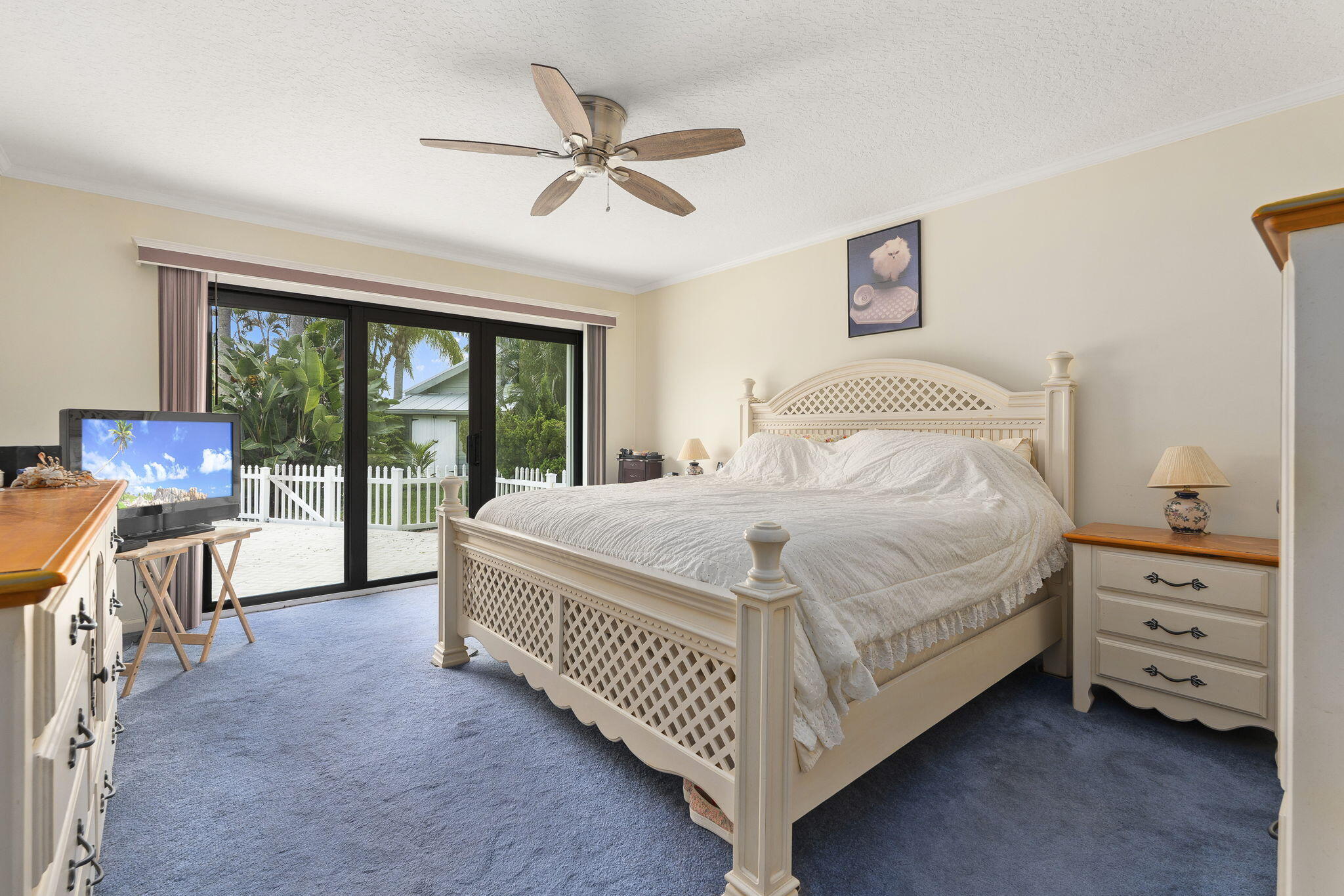 8964 Southeast Sunfish Place Hobe Sound, FL 33455 - Photo 30 of 51 a bedroom with a bed and a chandelier