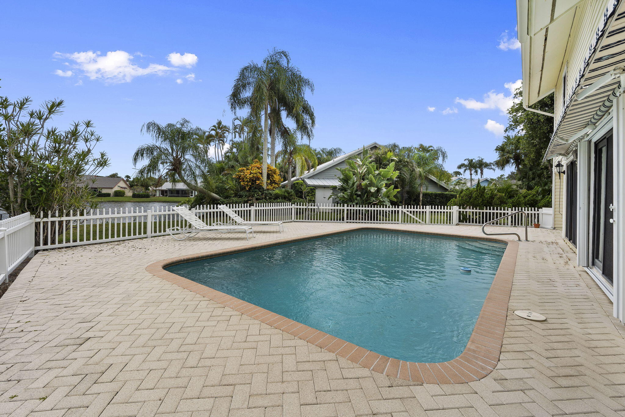 8964 Southeast Sunfish Place Hobe Sound, FL 33455 - Photo 38 of 51 a view of a swimming pool with a yard and palm trees