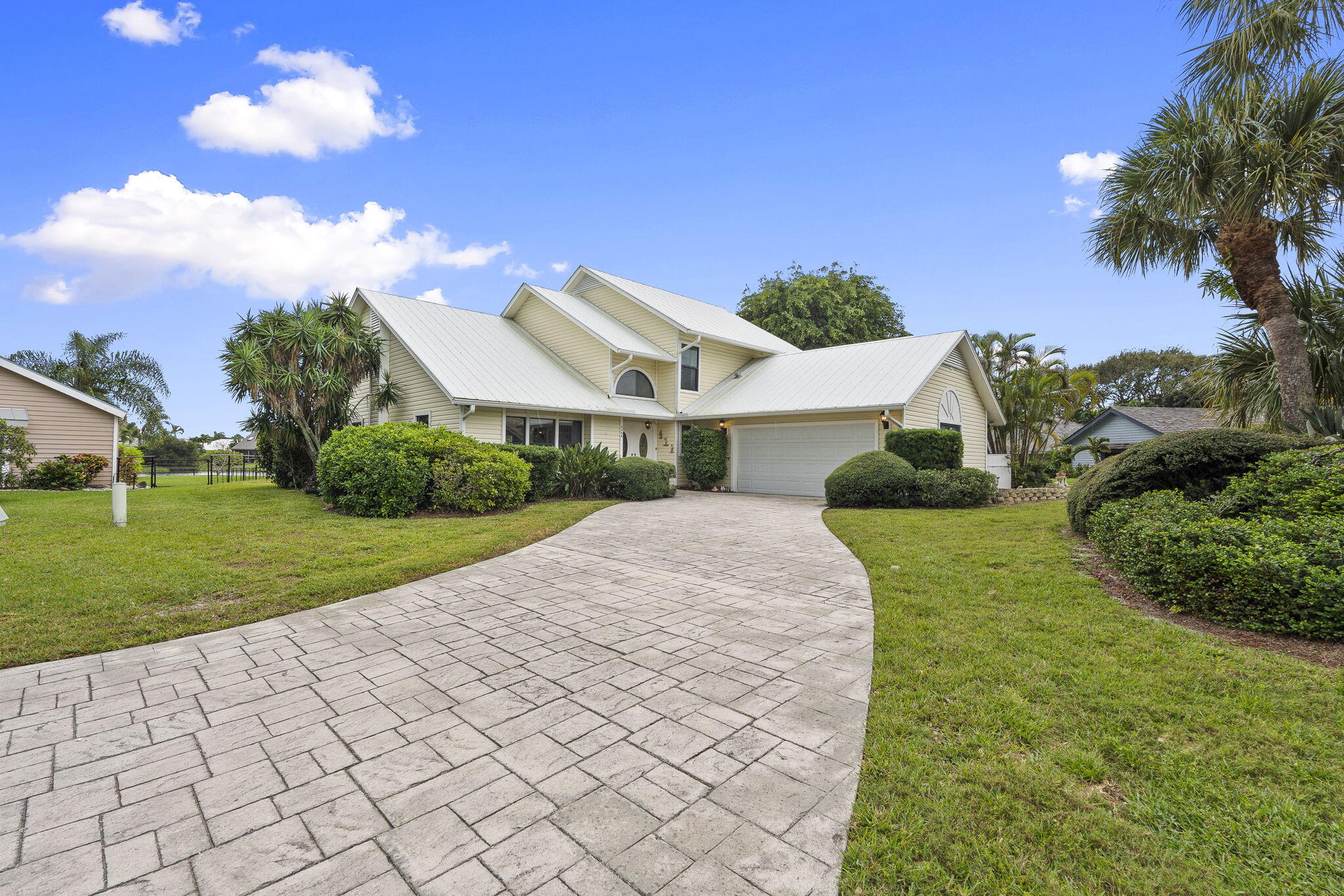 8964 Southeast Sunfish Place Hobe Sound, FL 33455 - Photo 5 of 51 a view of a house with a yard and potted plants