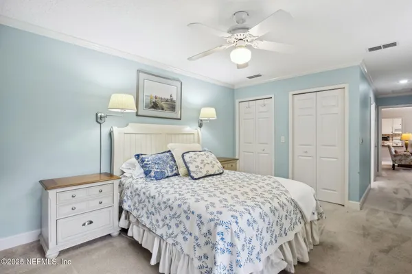 a bedroom with a large bed and a chandelier