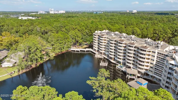 an aerial view of residential houses with outdoor space and lake view