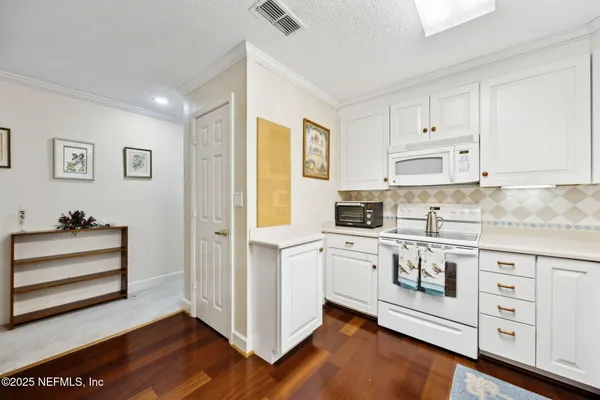 a kitchen with white cabinets and white appliances