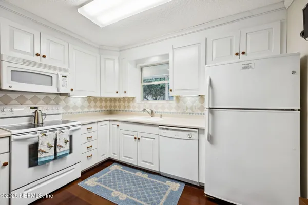 a kitchen with stainless steel appliances granite countertop a refrigerator sink and white cabinets