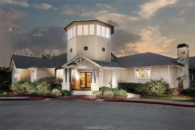 a front view of a house with a yard and potted plants