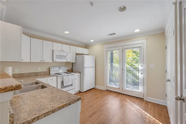 a kitchen with granite countertop cabinets stainless steel appliances a sink and a window