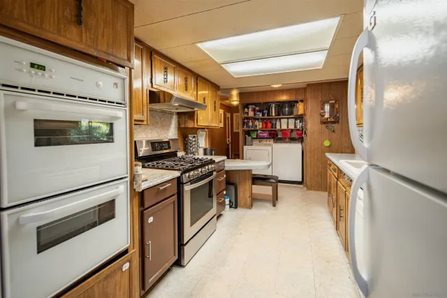 a kitchen with stainless steel appliances granite countertop a stove and a refrigerator