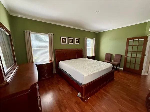 a bedroom with a bed and wooden floor