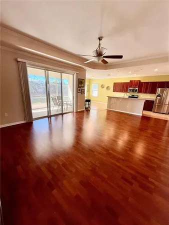 a view of an empty room with wooden floor and a floor to ceiling window
