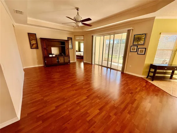 a view of empty room with wooden floor and fan
