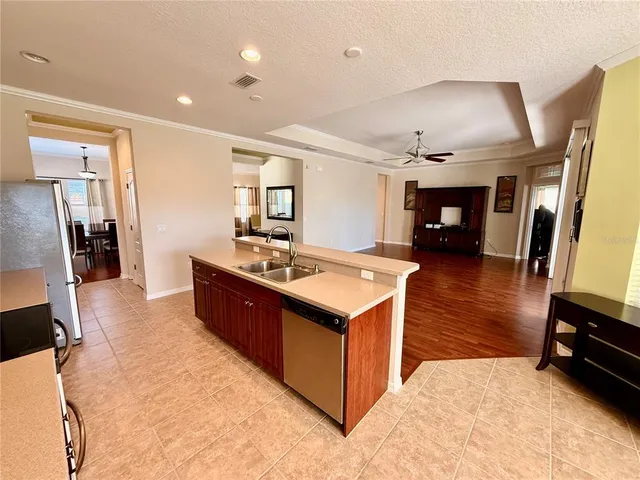 a spacious kitchen with stainless steel appliances granite countertop a sink stove and refrigerator