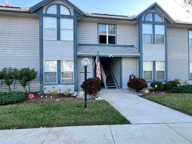 a front view of a house with a garden and plants