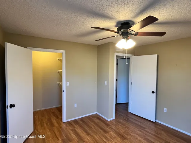 a view of an empty room with closet and a chandelier fan