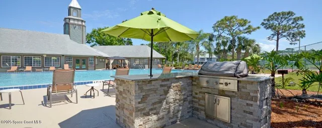 a view of a patio with table and chairs under an umbrella