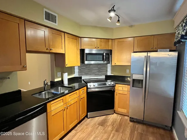 a kitchen with granite countertop stainless steel appliances and wooden cabinets