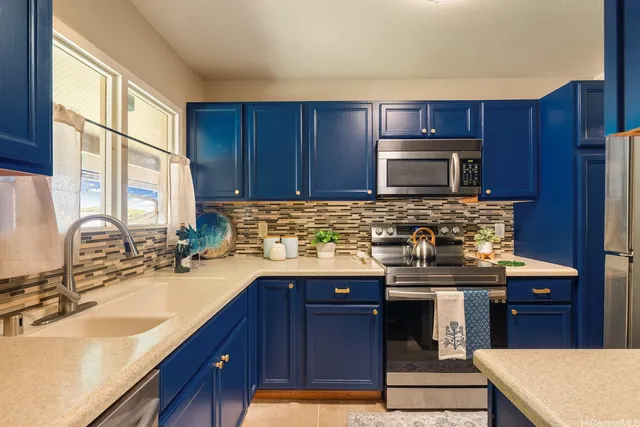 a kitchen with granite countertop a sink stove and microwave