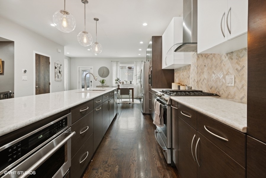 1745 North Troy Street Chicago, IL 60647 - Photo 5 of 29 a large kitchen with stainless steel appliances a large counter top a stove and a refrigerator