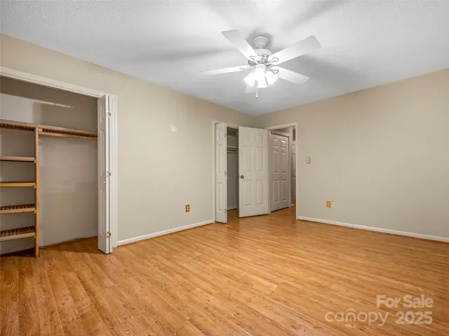 an empty room with closet and fan