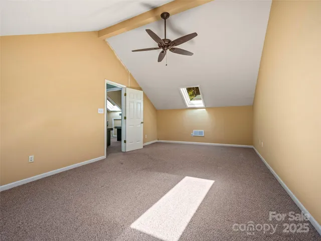 an empty room with a ceiling fan and window