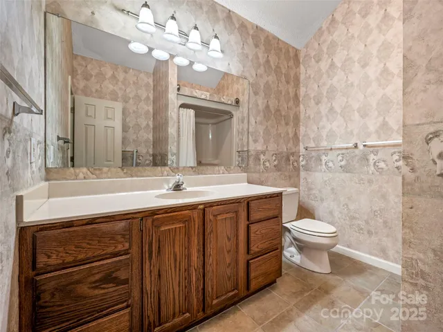 a bathroom with a double vanity sink mirror and toilet