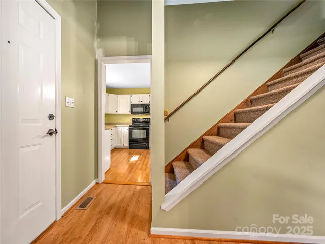 a view of a hallway with wooden floor and staircase