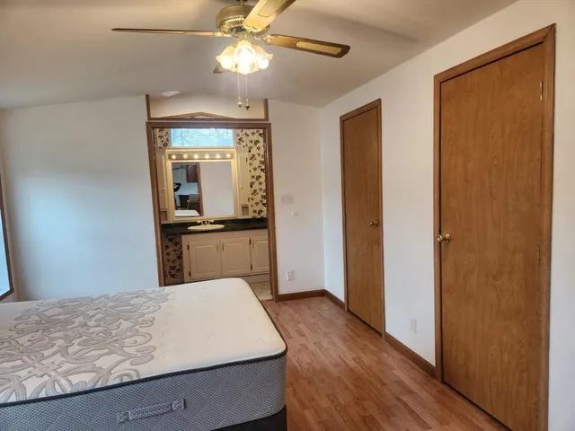 a view of a bedroom with wooden floor and closet