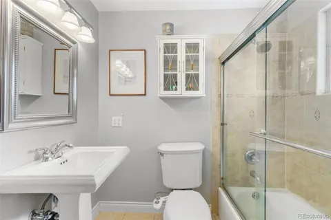 a bathroom with a toilet a sink and mirror