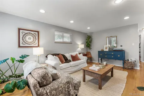 a living room with furniture and paintings on the wall