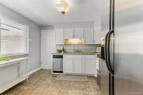 a kitchen with a refrigerator sink and cabinets