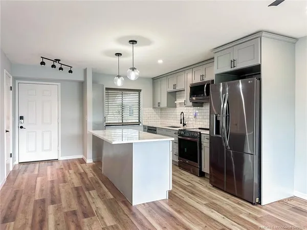 a large kitchen with a large window and stainless steel appliances