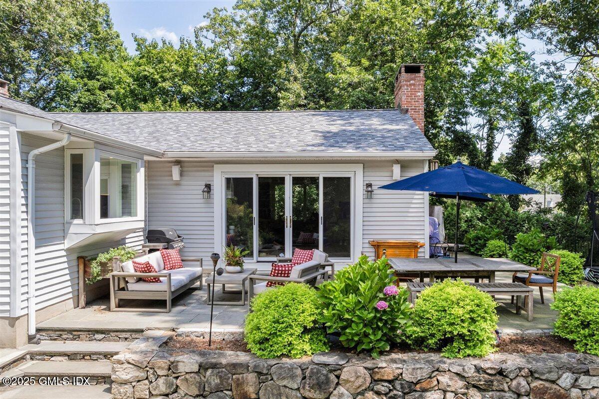 44 Bote Road Greenwich, CT 06830 - Photo 26 of 30 a backyard of a house with table and chairs under an umbrella