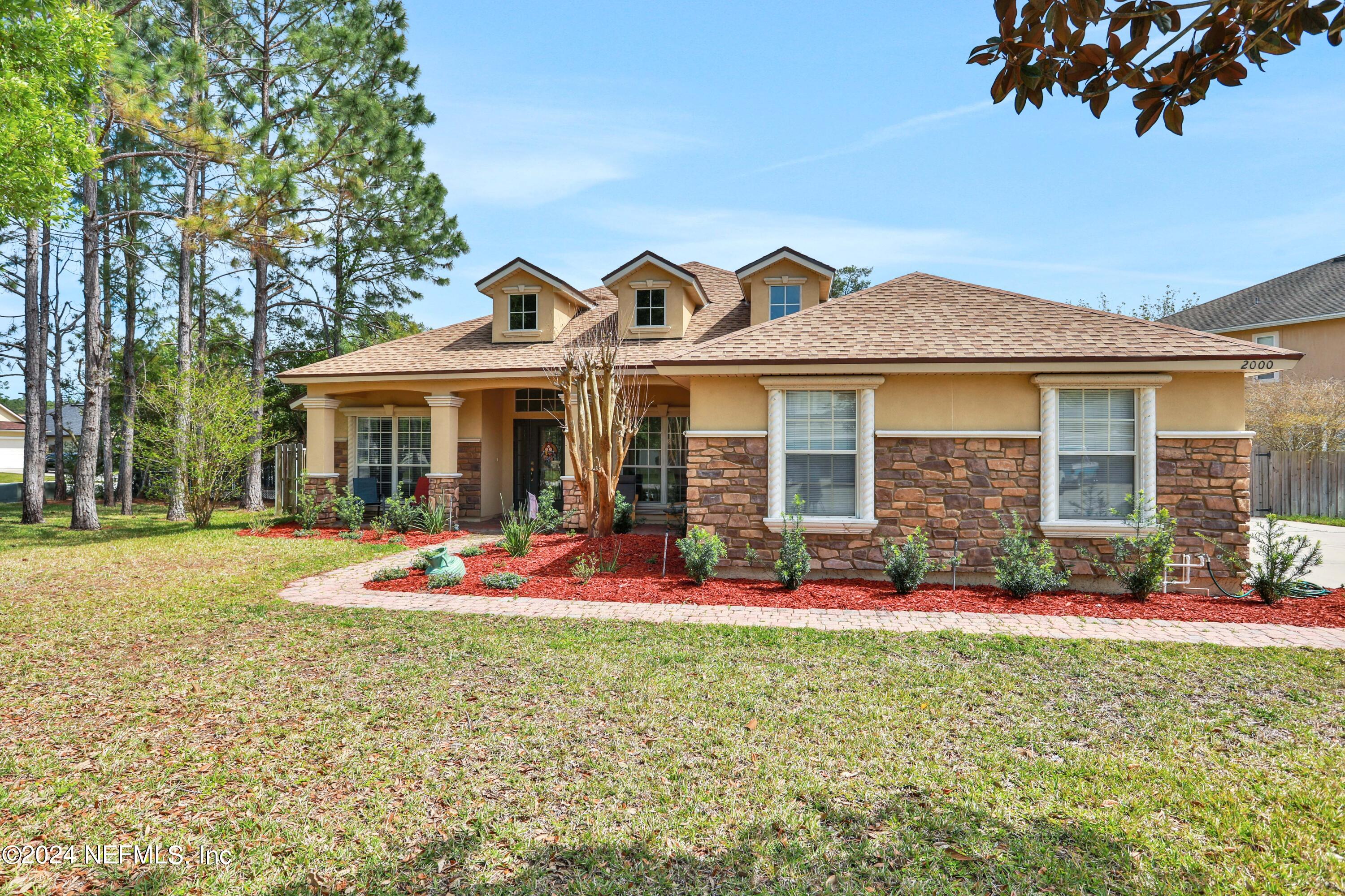 2000 Spring Meadows Court St. Augustine, FL 32092 - Photo 1 of 40 a front view of a house with a yard porch and outdoor seating