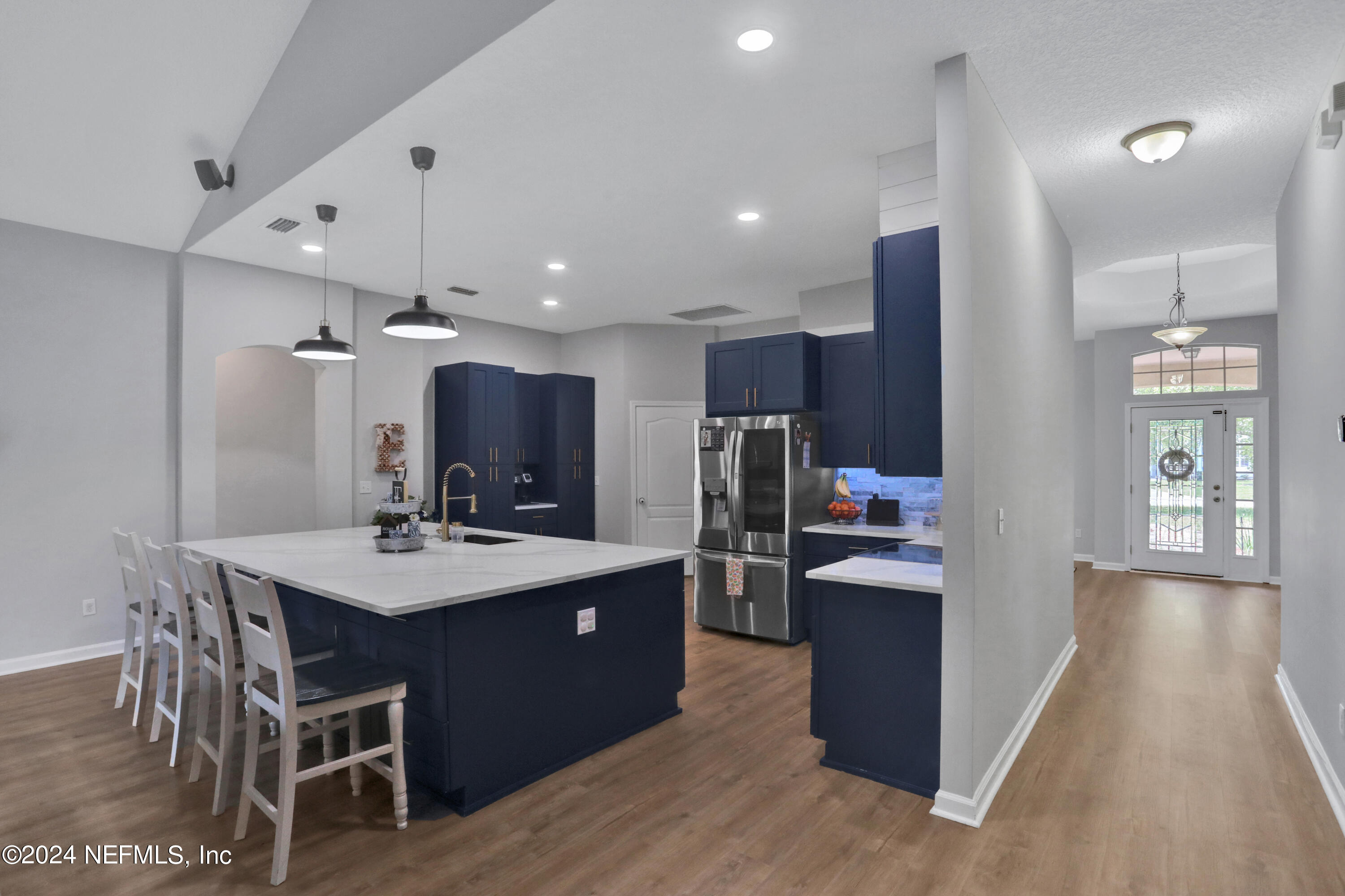 2000 Spring Meadows Court St. Augustine, FL 32092 - Photo 21 of 40 a kitchen with stainless steel appliances kitchen island granite countertop a table chairs and a refrigerator