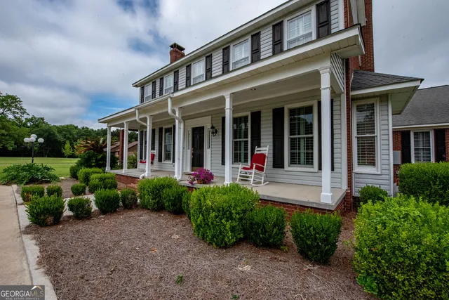 a view of a green field with wooden fence