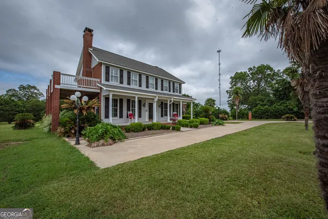a backyard of a house with table and chairs potted plants