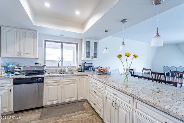 a kitchen with granite countertop cabinets and wooden floor