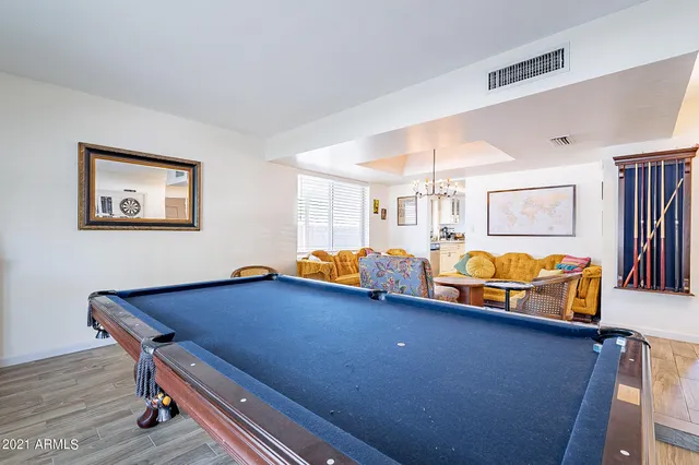 a room with pool table and windows