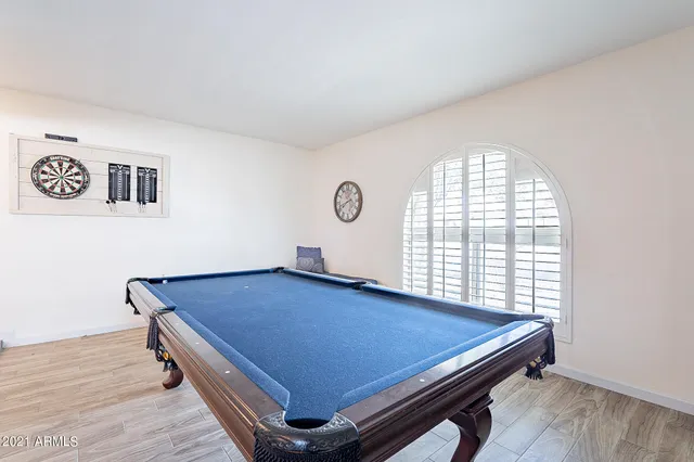 a room with pool table and wooden floor