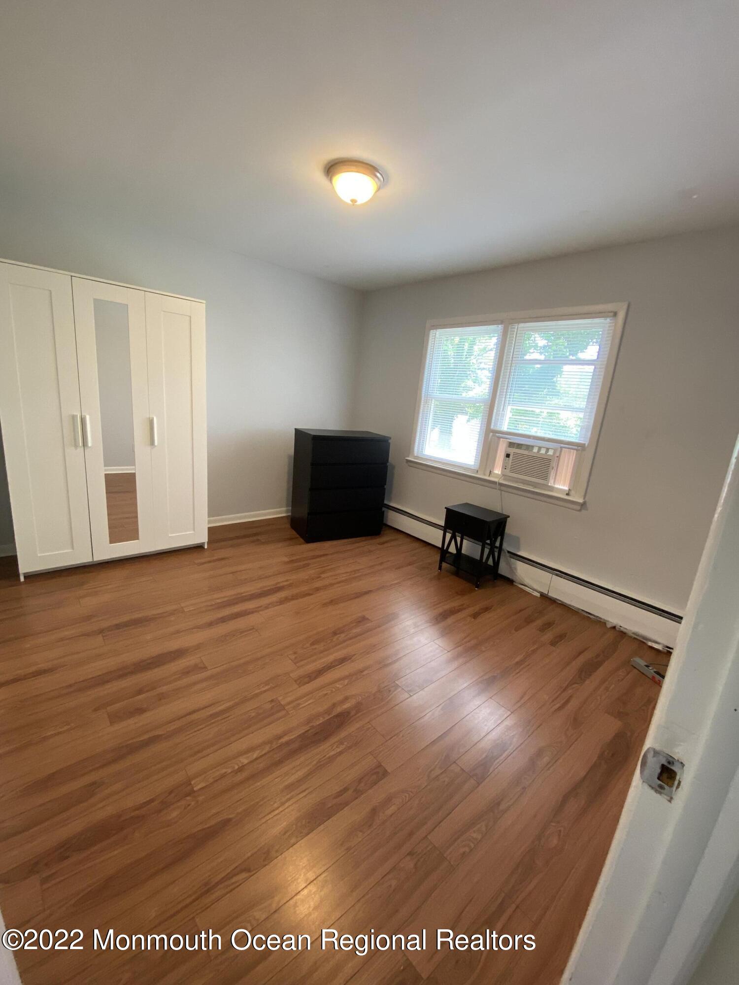9 Howland Avenue, Unit 2 Long Branch, NJ 07740 - Photo 5 of 8 an empty room with wooden floor wooden floor and windows
