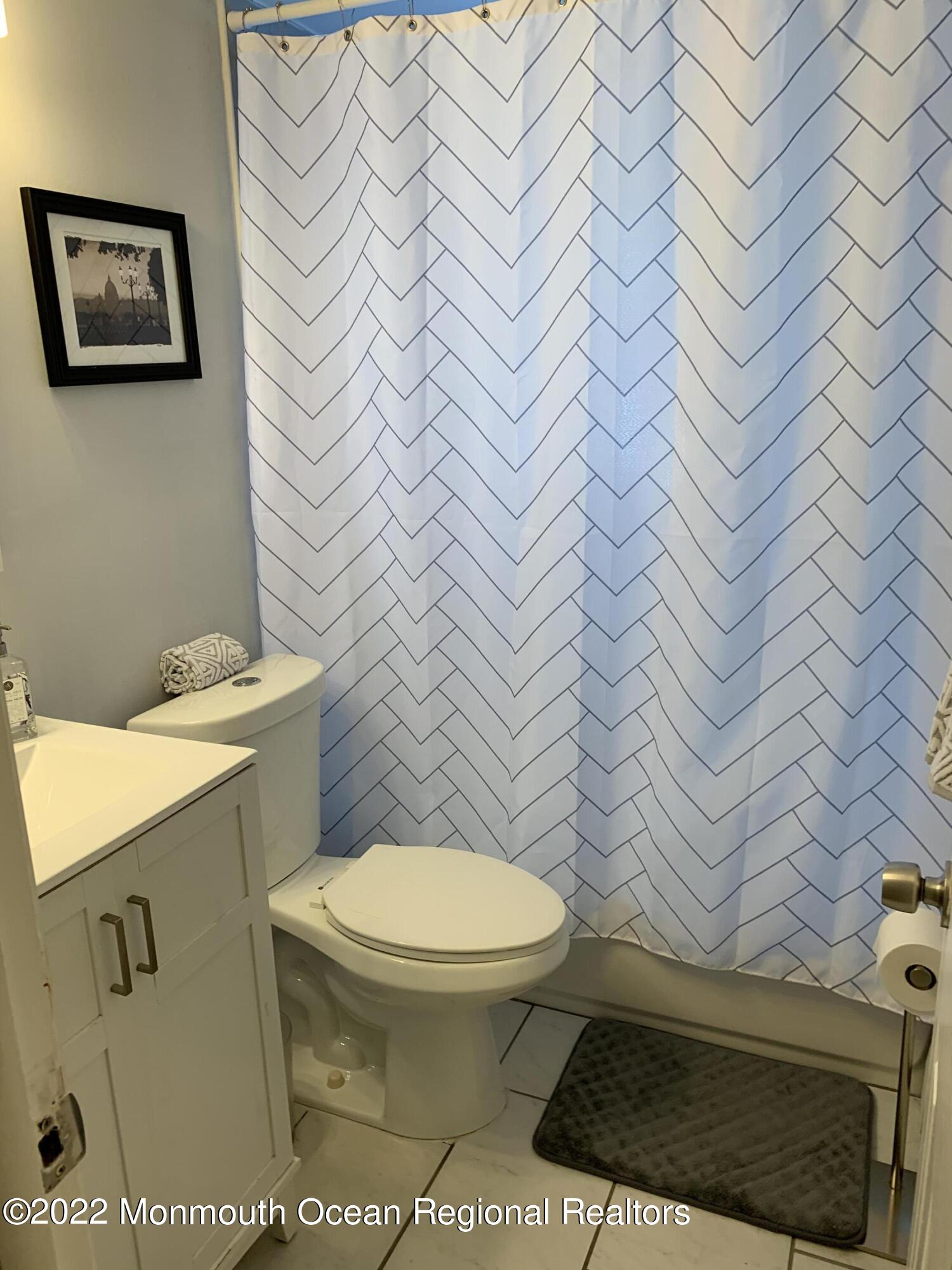 9 Howland Avenue, Unit 2 Long Branch, NJ 07740 - Photo 6 of 8 a bathroom with a toilet and a shower curtain