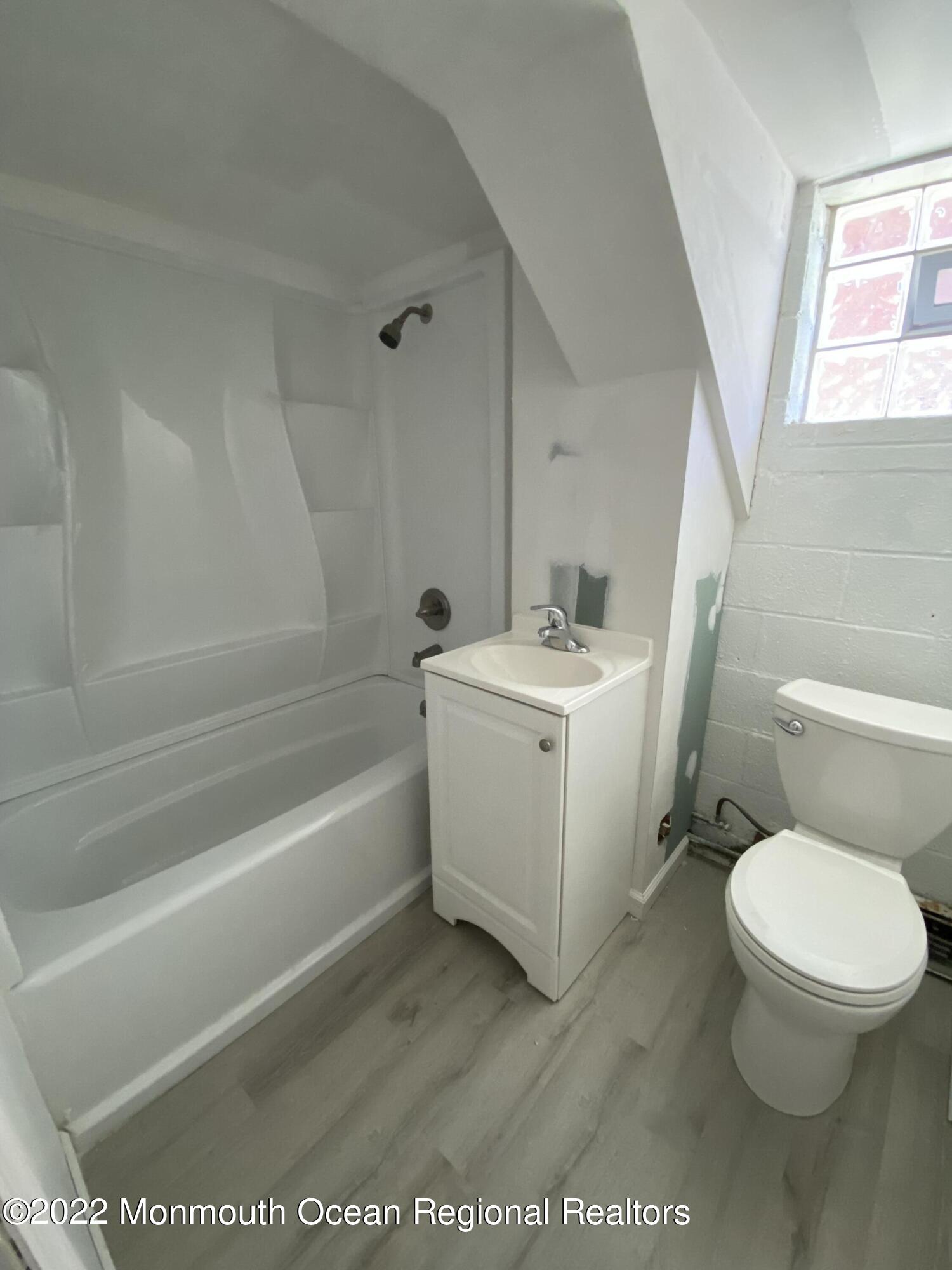 9 Howland Avenue, Unit 2 Long Branch, NJ 07740 - Photo 7 of 8 a white toilet sitting next to a bath tub