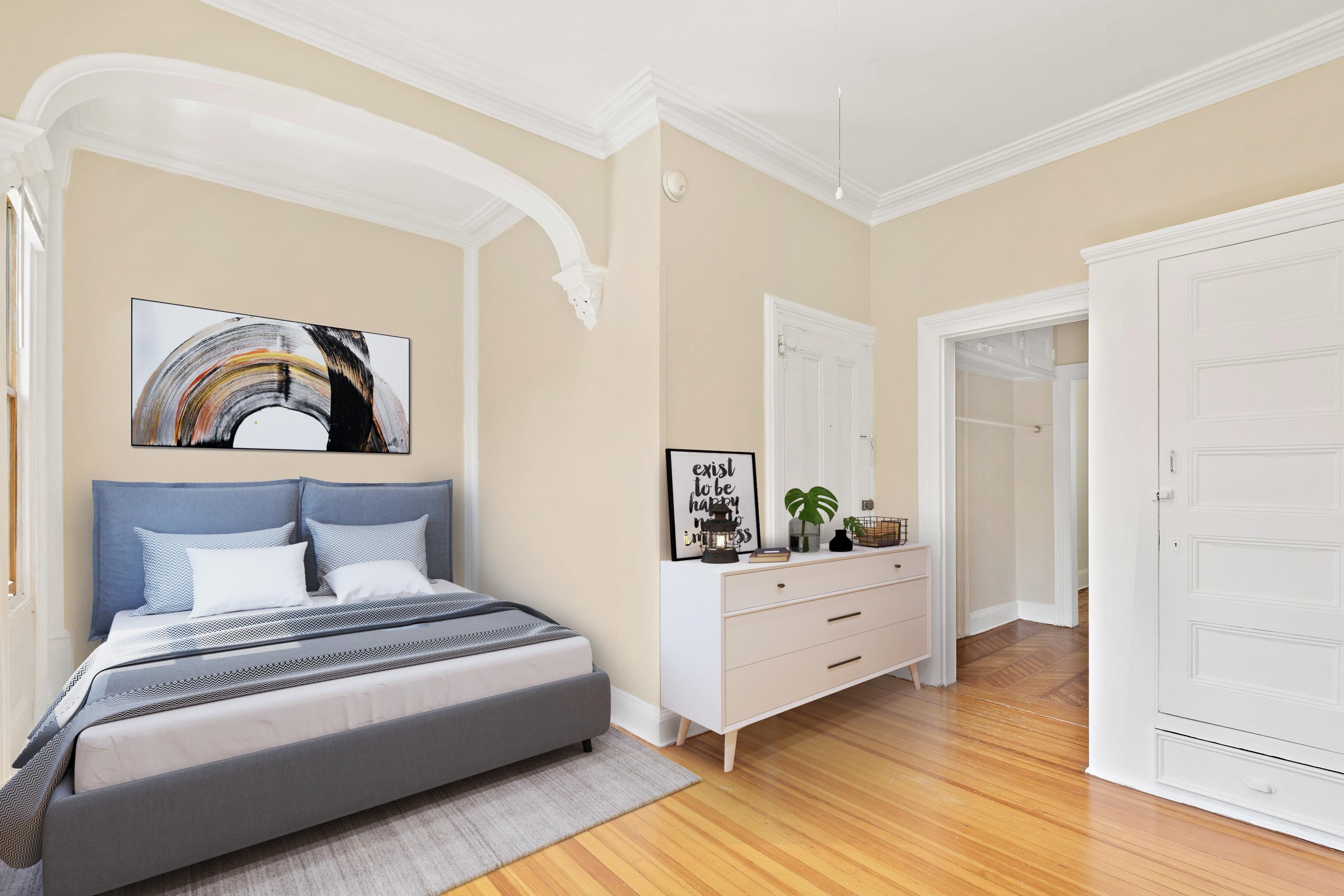 a bedroom with a large bed and wooden floor