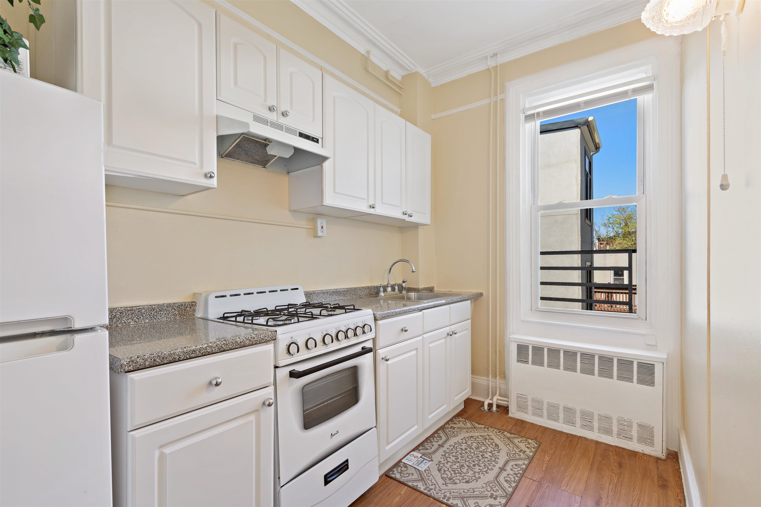 804 Bloomfield Street, Unit 2 Hoboken, NJ 07030 - Photo 7 of 14 a kitchen with granite countertop a stove a sink and a white cabinets