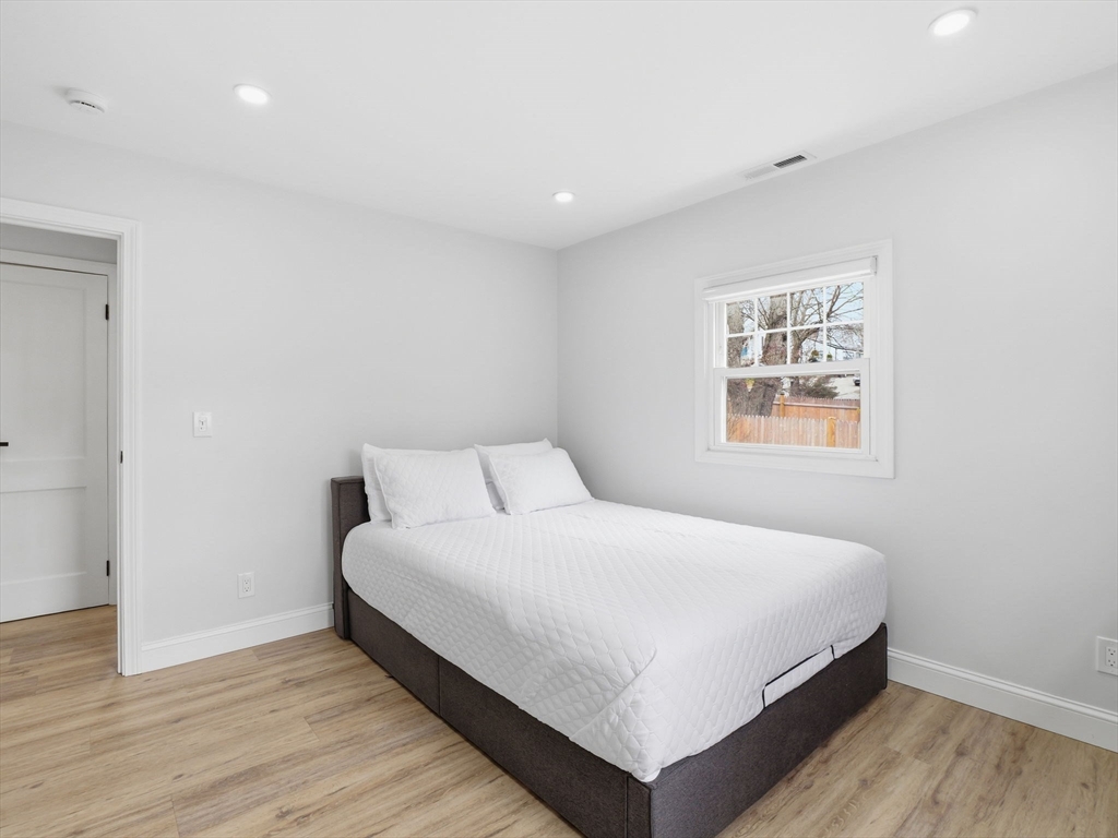 63 Jasper Street Saugus, MA 01906 - Photo 17 of 39 a large bedroom with a bed and a night stand
