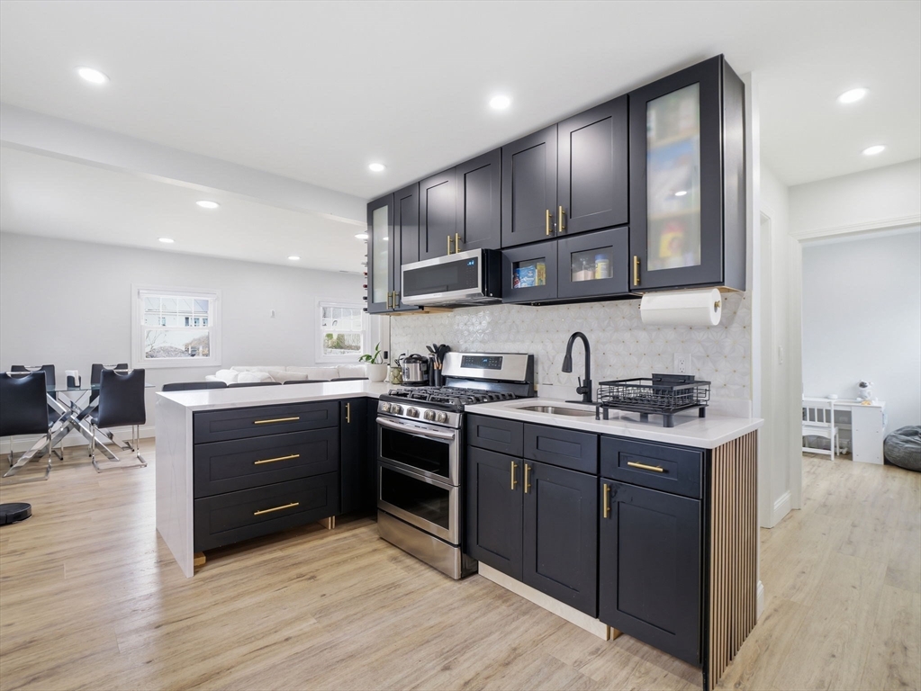 63 Jasper Street Saugus, MA 01906 - Photo 2 of 39 a kitchen with stainless steel appliances granite countertop a sink stove and cabinets