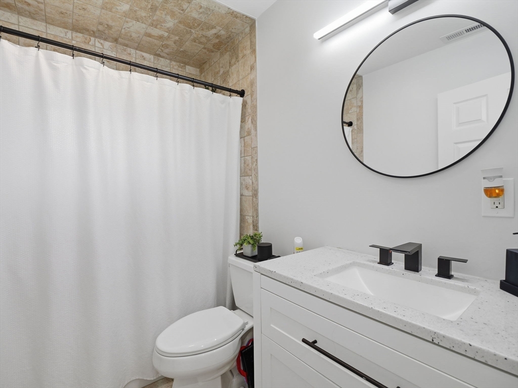 63 Jasper Street Saugus, MA 01906 - Photo 23 of 39 a bathroom with a sink a toilet and a mirror