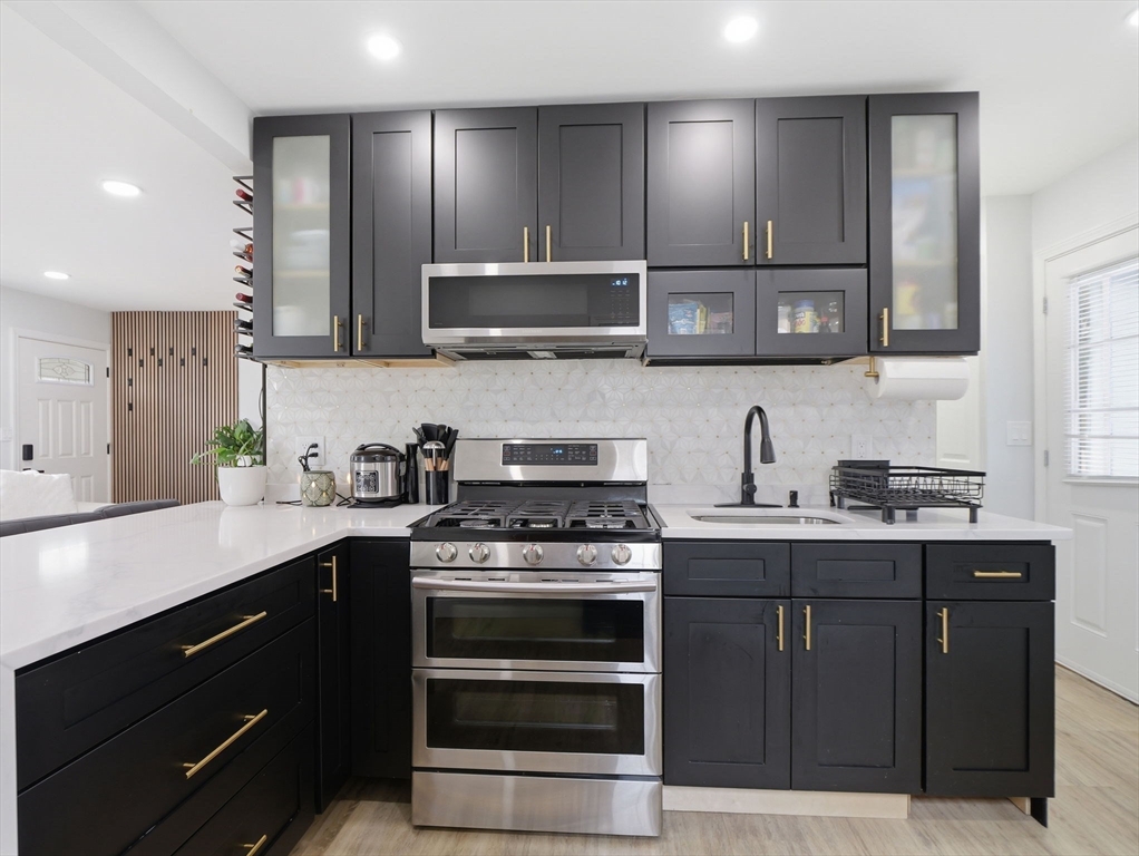 63 Jasper Street Saugus, MA 01906 - Photo 6 of 39 a kitchen with stainless steel appliances granite countertop a stove a sink and a microwave