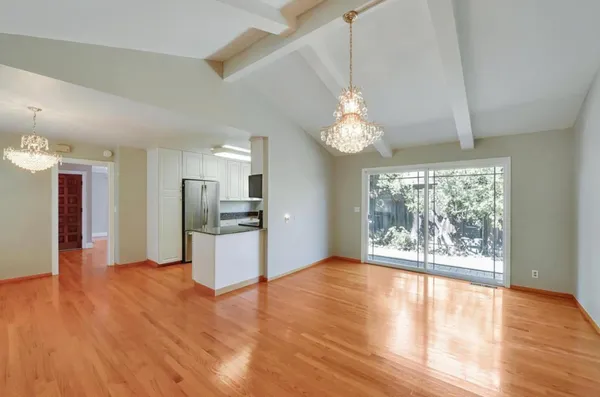 a view of a big room with wooden floor and a kitchen